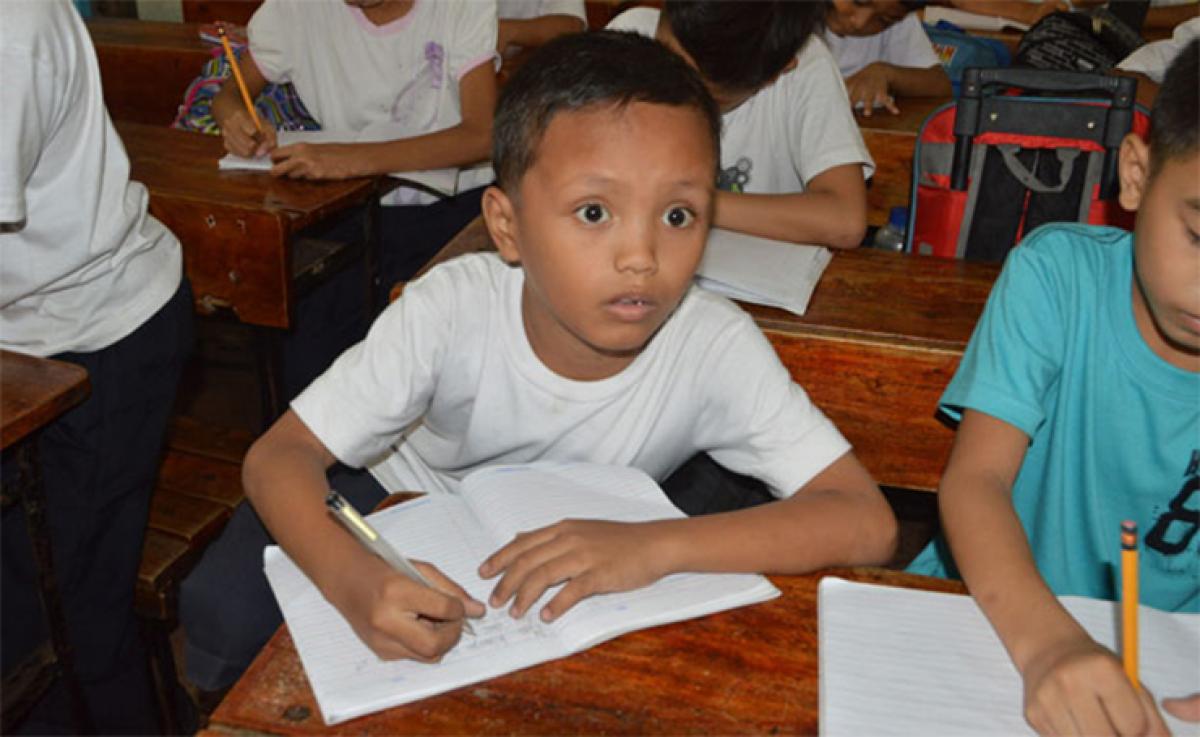 Filipino boy’s photo studying on street goes viral; donations pour in